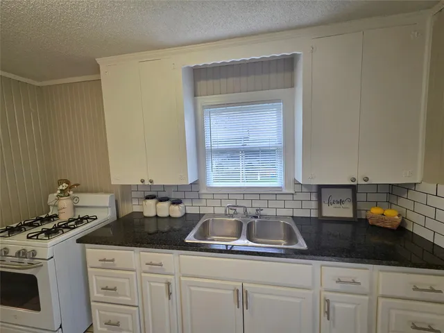 a kitchen with a sink stove and cabinets