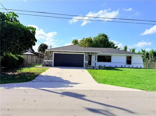 a front view of a house with a yard and a garage