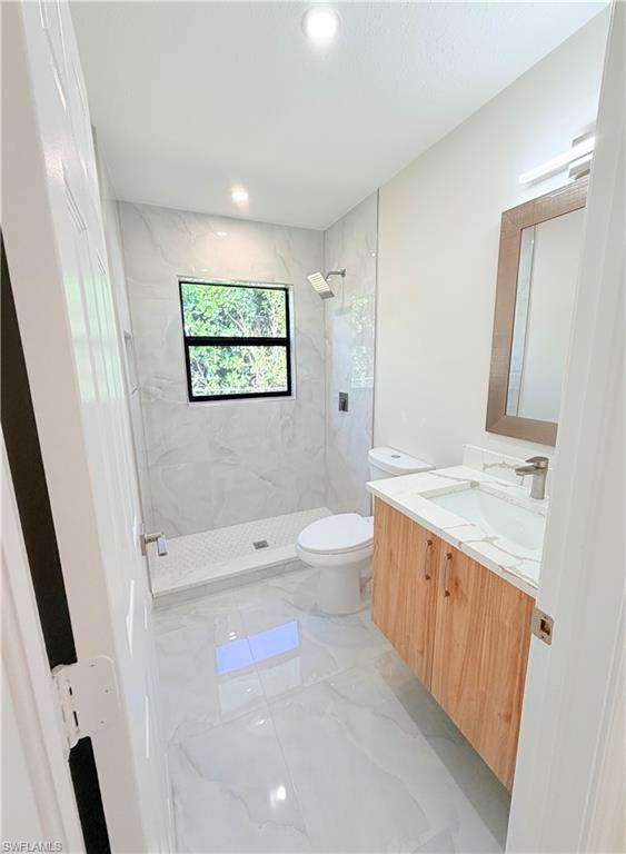 4212 32nd Avenue Southwest Naples, FL 34116 - Photo 10 of 27 a spacious bathroom with a granite countertop sink a toilet and a bathtub