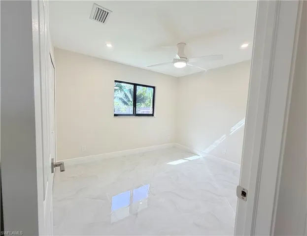 a spacious bathroom with a granite countertop sink a toilet and a bathtub