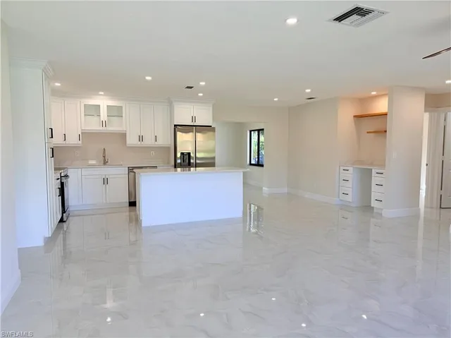 a view of kitchen with refrigerator and window