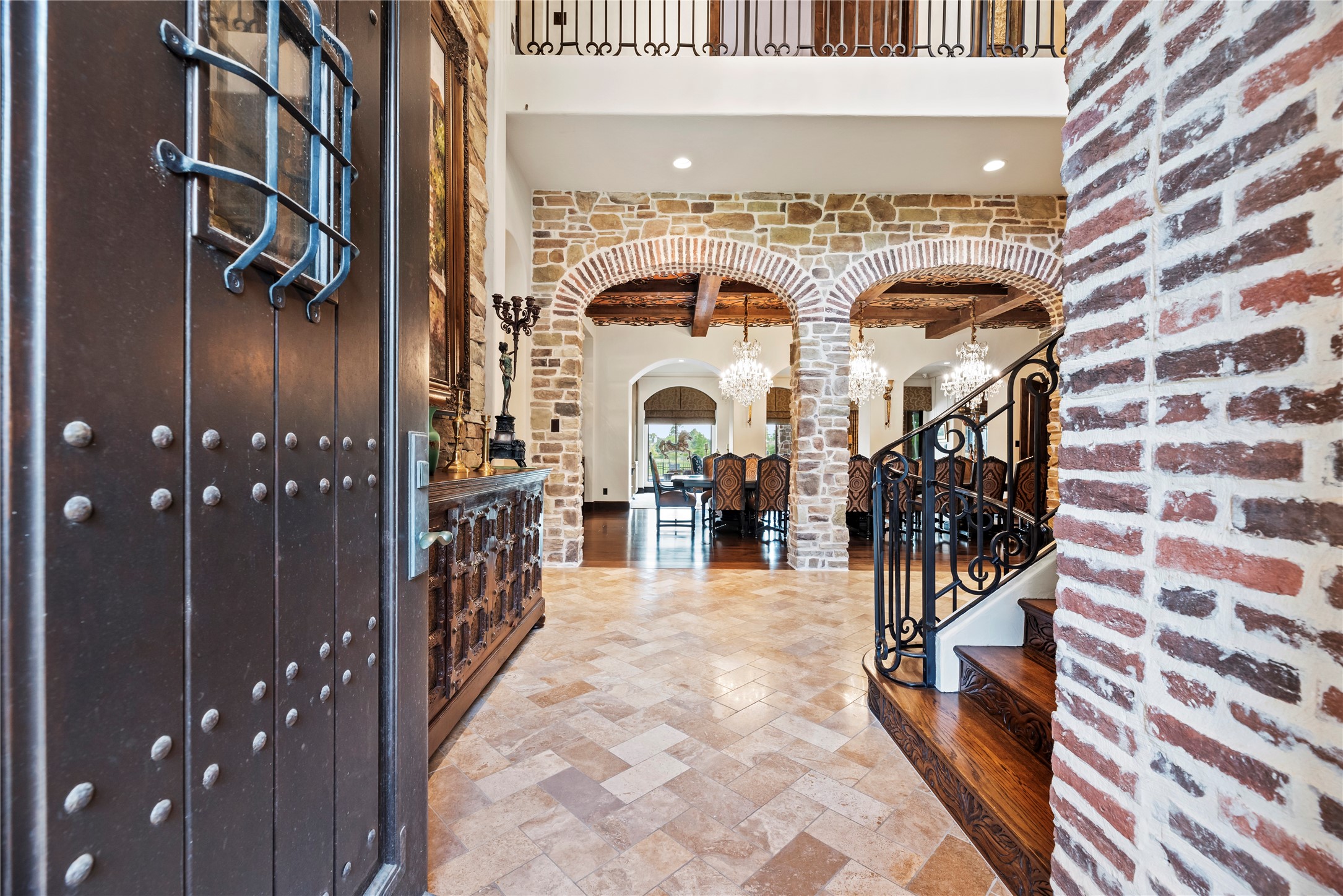 7715 Firethorne Creek Court Spring, TX 77389 - Photo 7 of 50 Step into elegance through a grand entryway featuring rustic stone arches, intricate wrought iron details, and a warm, inviting ambiance.