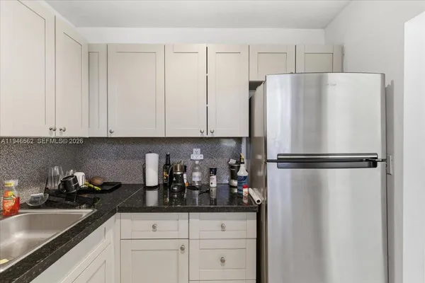 a kitchen with appliances a refrigerator and cabinets