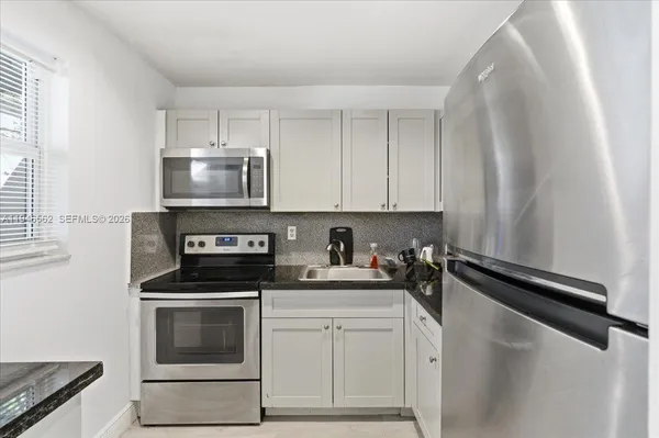 a kitchen with a sink stove and microwave