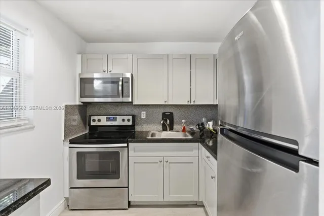 a kitchen with a sink stove and microwave