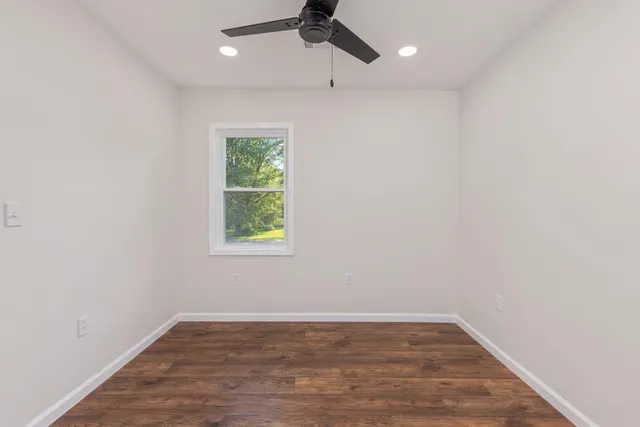 an empty room with a window and a ceiling fan