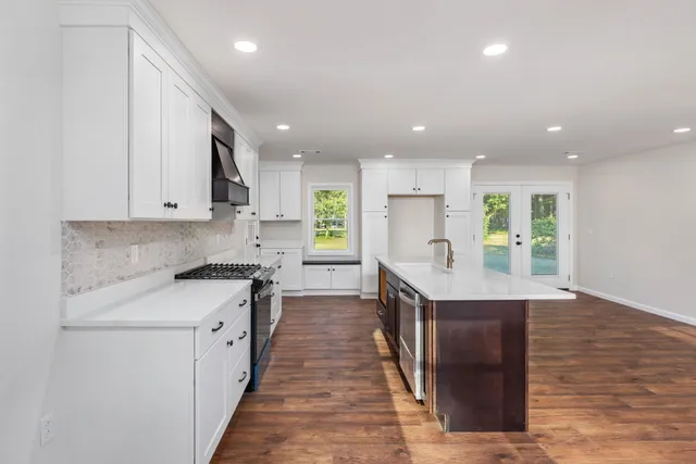 a kitchen with white cabinets sink and stainless steel appliances