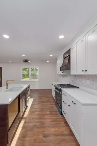a kitchen with stainless steel appliances granite countertop a sink and stove top oven