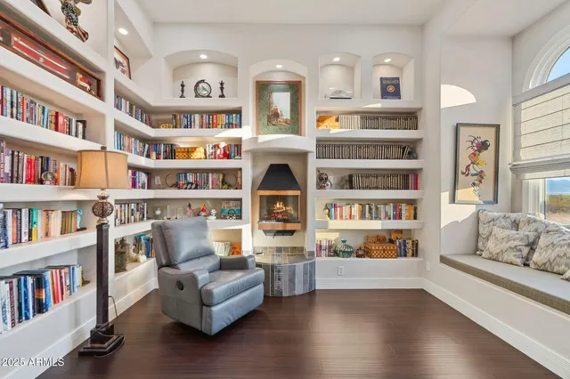 a living room with fireplace furniture and a book shelf