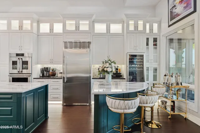 a kitchen with stainless steel appliances granite countertop a stove a refrigerator a dining table and chairs