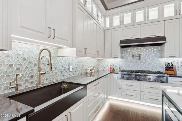 a kitchen with granite countertop a stove and a sink