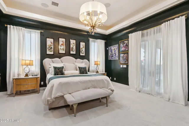 a spacious bedroom with a bed and a chandelier