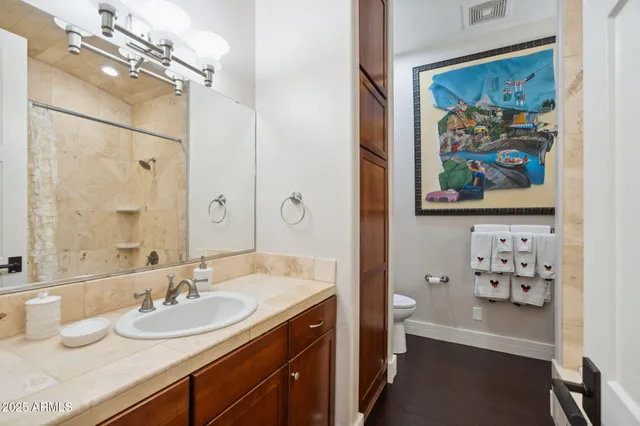 a bathroom with a granite countertop sink a toilet and a mirror