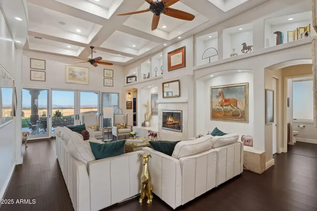 a living room with furniture a fireplace and a ceiling fan