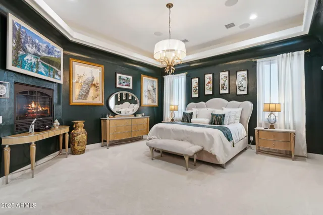 a spacious bedroom with a bed and a chandelier