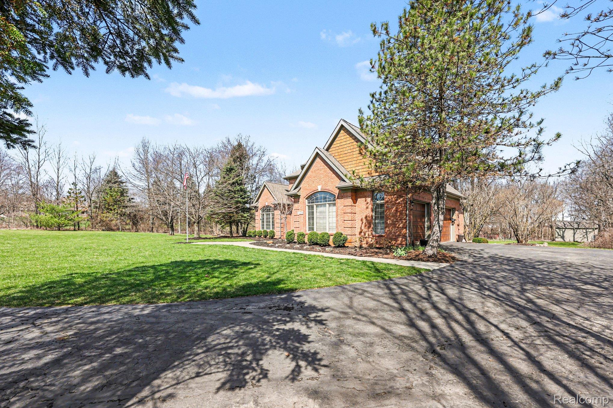 55256 Lee Road New Hudson, MI 48165 - Photo 3 of 28 View of front facade with a front yard and asphalt driveway