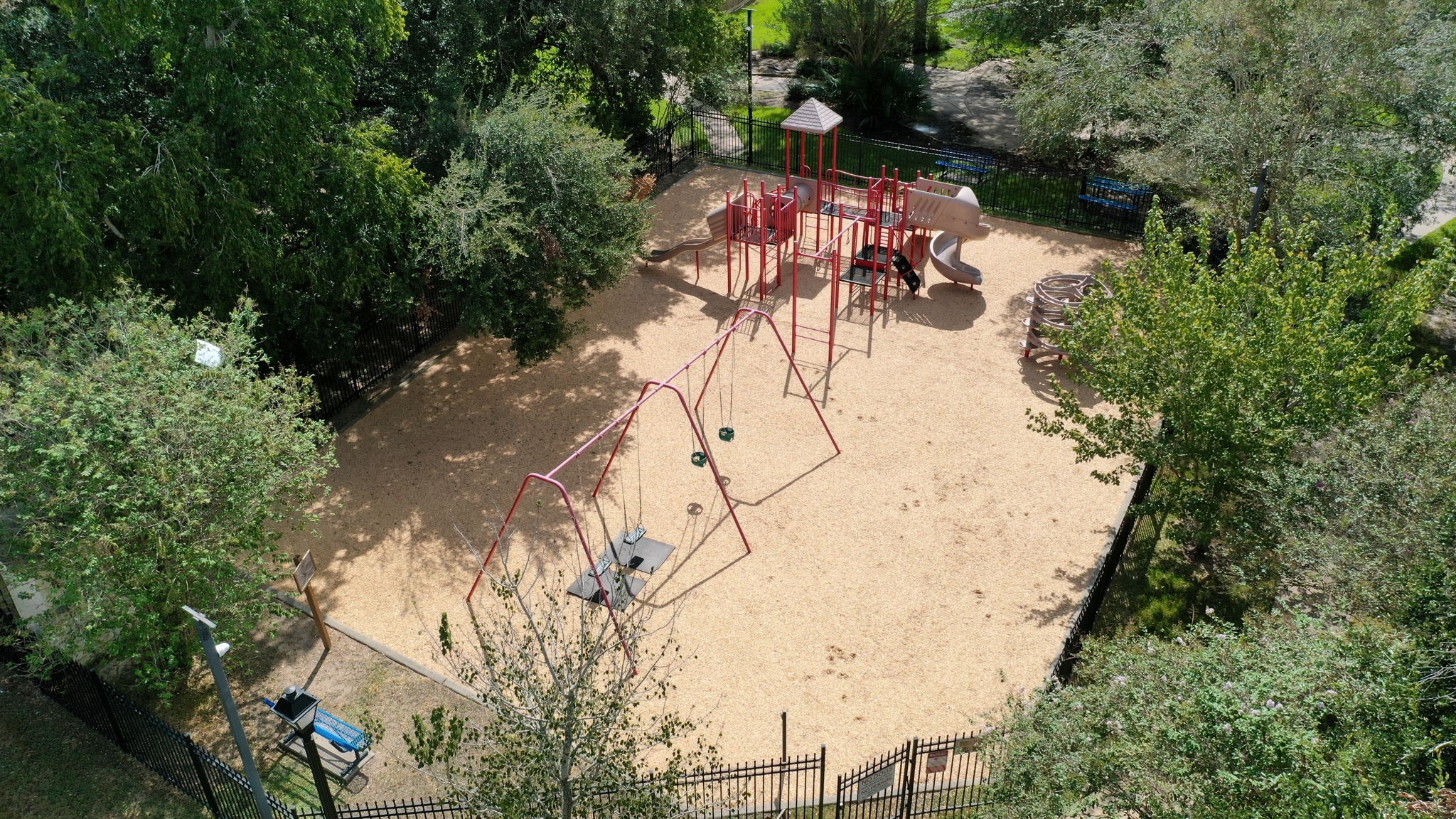 19519 Ricelake Lane Houston, TX 77084 - Photo 43 of 47 Charming community playground surrounded by lush greenery, featuring swings, slides, and climbing structures for endless outdoor fun.