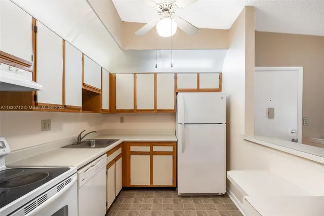 a kitchen with a refrigerator sink and cabinets