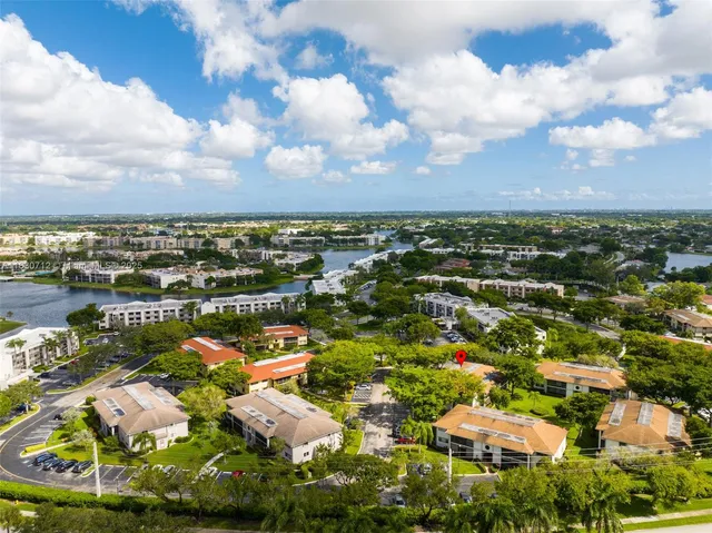 an aerial view of residential houses with outdoor space and ocean