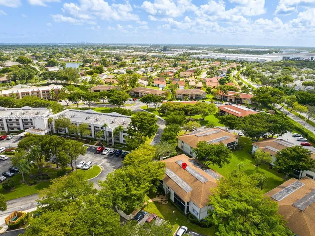 a front view of a house with a garden and trees