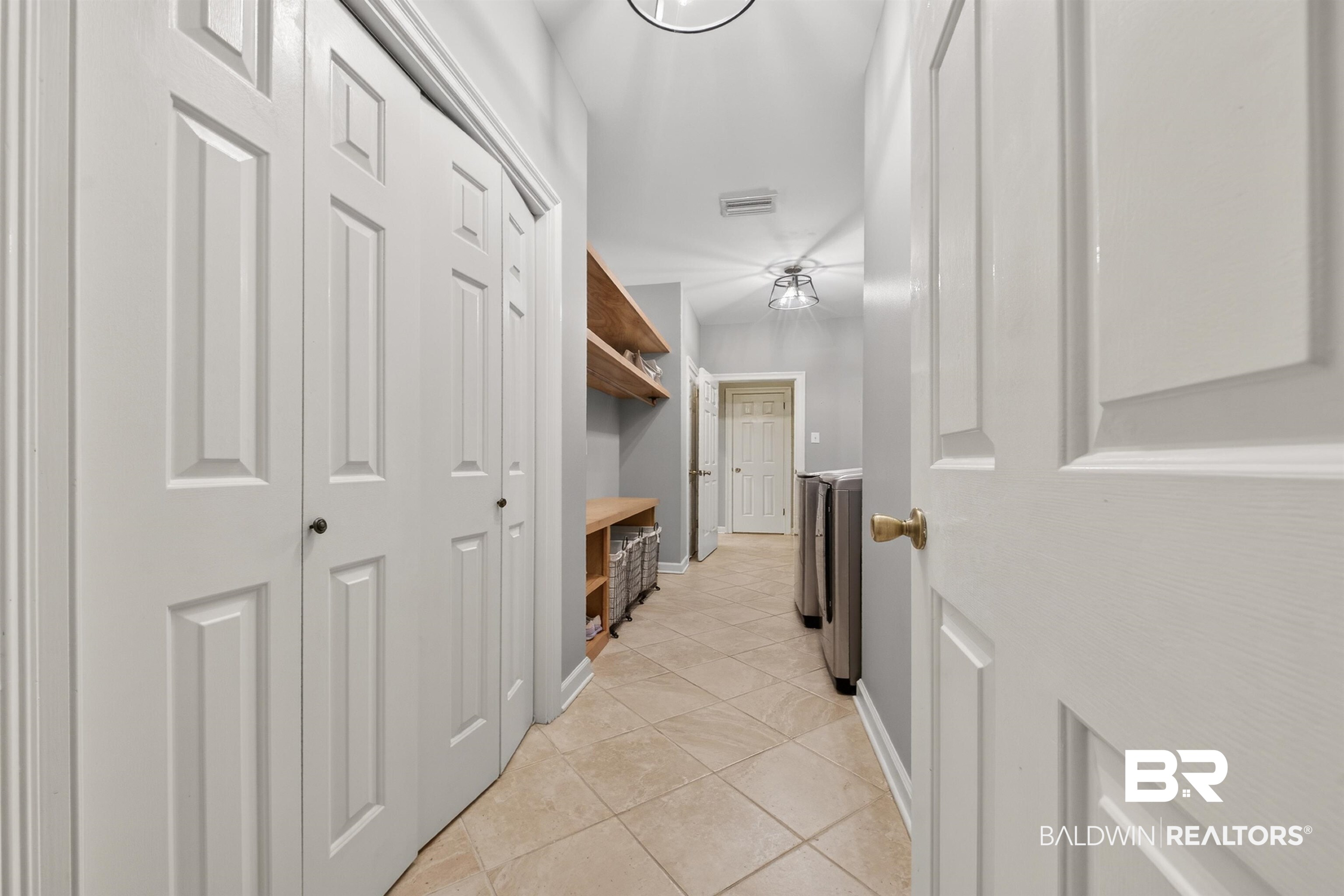 1250 Savannah Drive Mobile, AL 36609 - Photo 29 of 35 Hallway with light tile patterned floors and washer / dryer