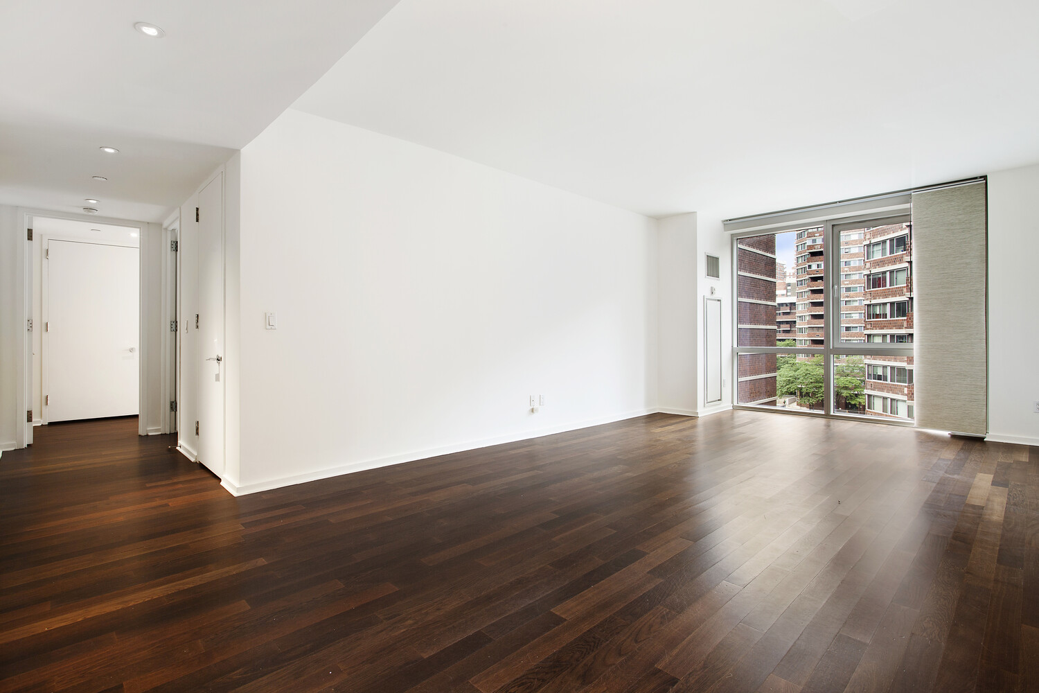 340 East 23rd Street, Unit 6E Manhattan, NY 10010 - Photo 1 of 6 a view of an empty room with wooden floor and a window