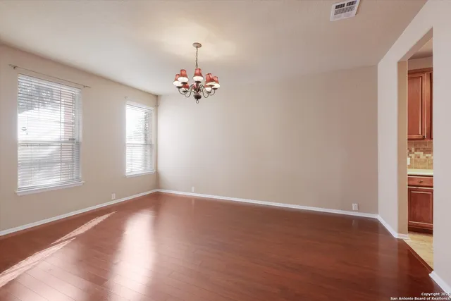 an empty room with wooden floor and window