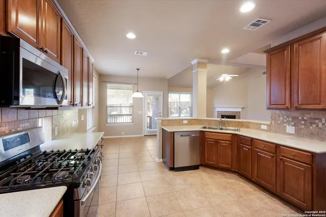 a large kitchen with stainless steel appliances granite countertop a stove and a sink
