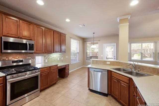 a kitchen with stainless steel appliances granite countertop a sink stove and microwave