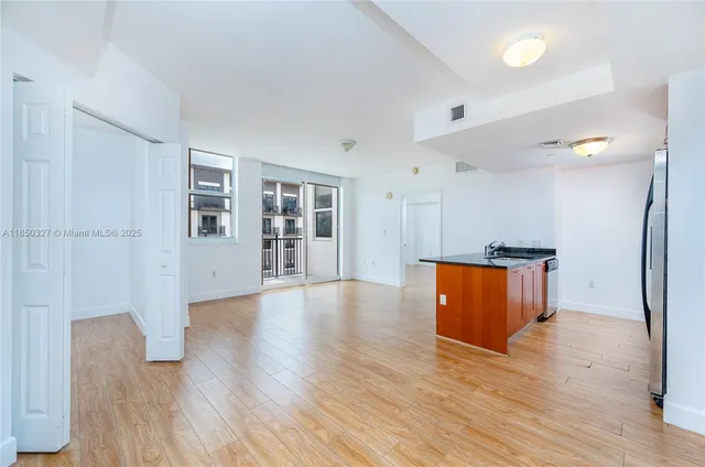 a view of a kitchen with wooden floor and a window