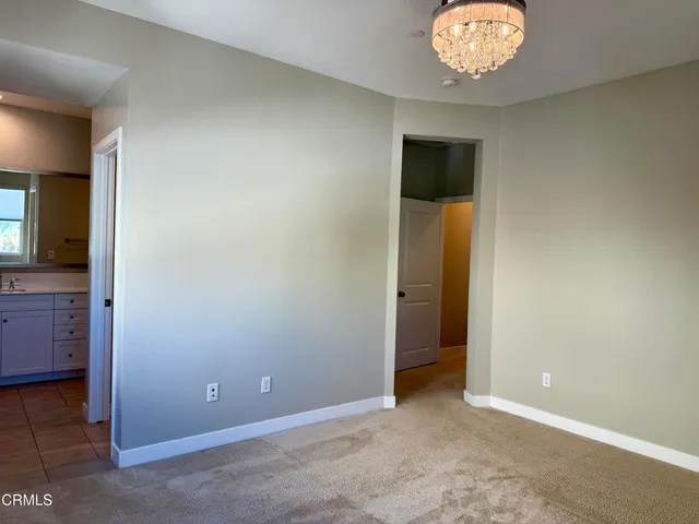an empty room with chandelier fan