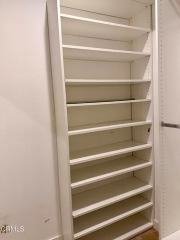 a view of walk in closet with empty racks