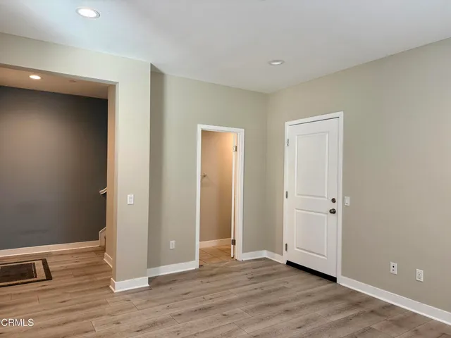 an empty room with wooden floor and closet