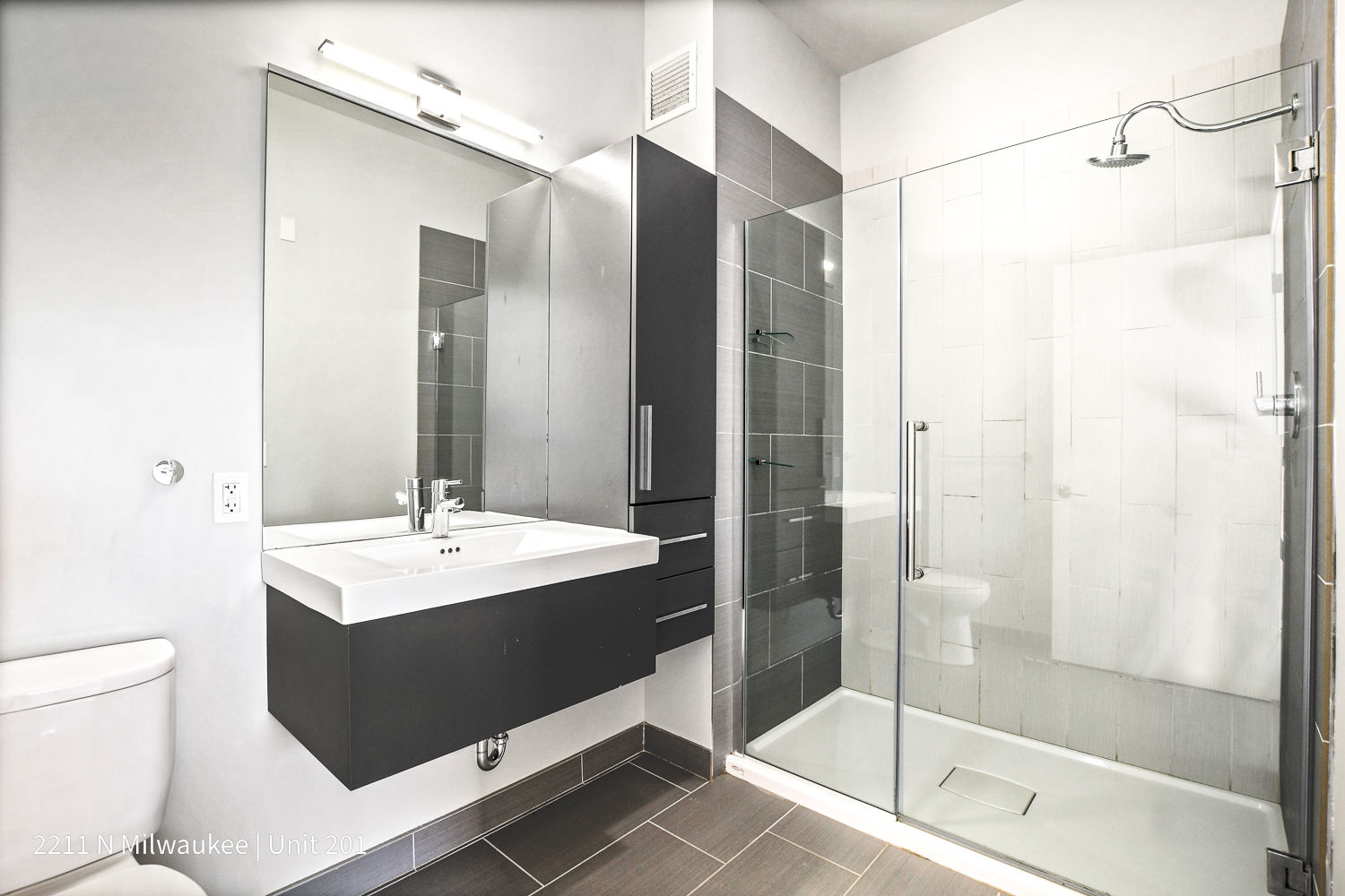 Undisclosed Address Chicago, IL 60647 - Photo 12 of 23 a bathroom with a bathtub shower sink vanity and toilet