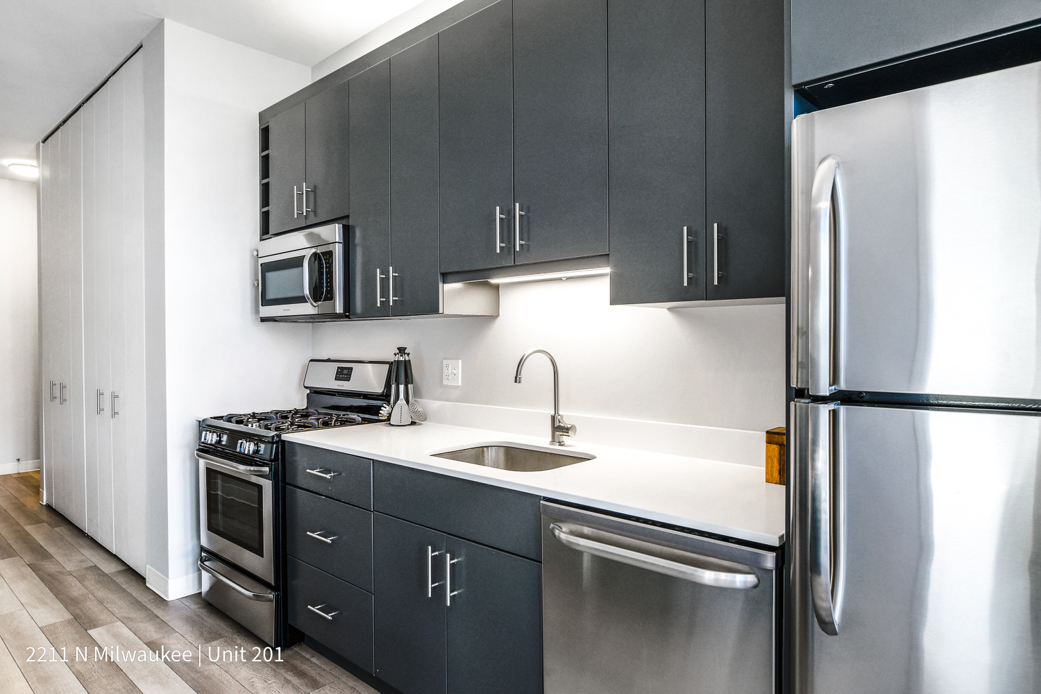Undisclosed Address Chicago, IL 60647 - Photo 9 of 23 a kitchen with a sink a refrigerator and a stove top oven