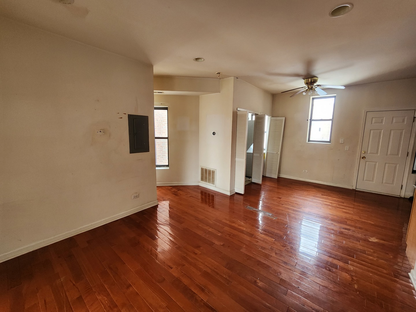 346 East 41st Street, Unit 2 Chicago, IL 60653 - Photo 4 of 9 an empty room with wooden floor and windows