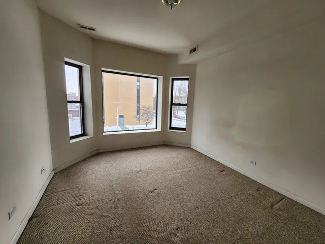 an empty room with a window and a ceiling fan