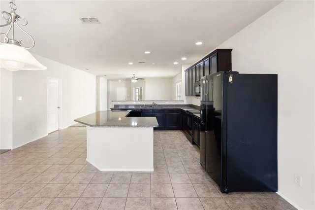 a large kitchen with a large counter top stainless steel appliances and cabinets