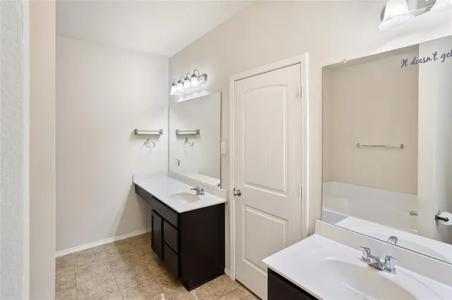 a bathroom with a tub sink and mirror