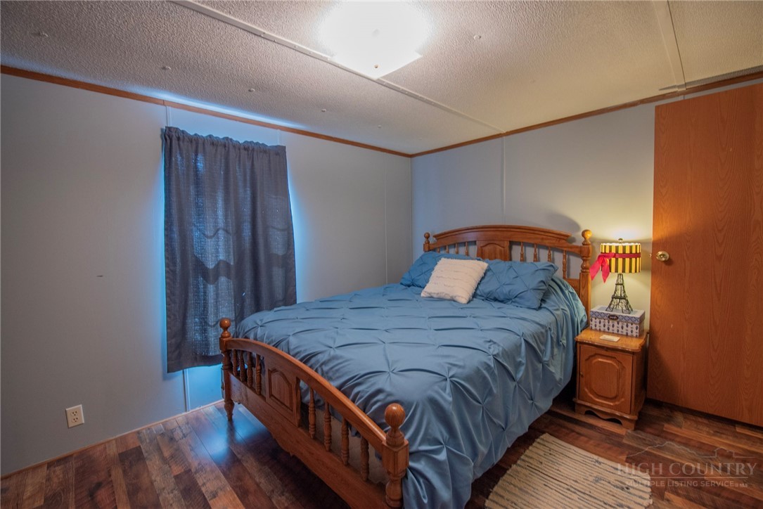 1848 West Mill Creek Road Warrensville, NC 28693 - Photo 40 of 50 a bedroom with a bed and wooden floor