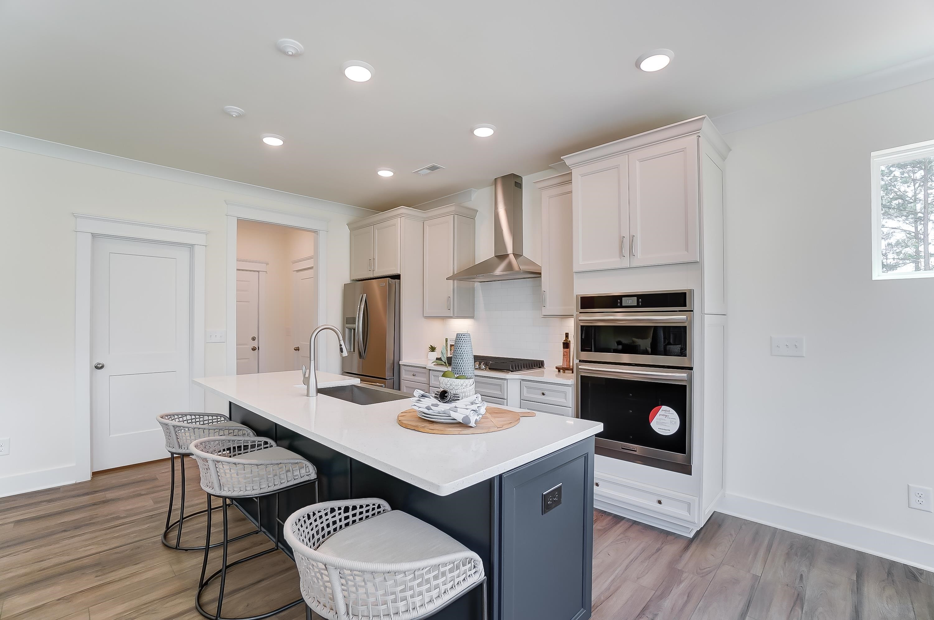 3450 Piedmont Drive Raleigh, NC 27604 - Photo 8 of 34 a kitchen with a sink dishwasher a dining table and chairs with wooden floor