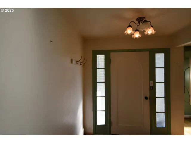 a view of a hallway with a chandelier fan and wooden floor