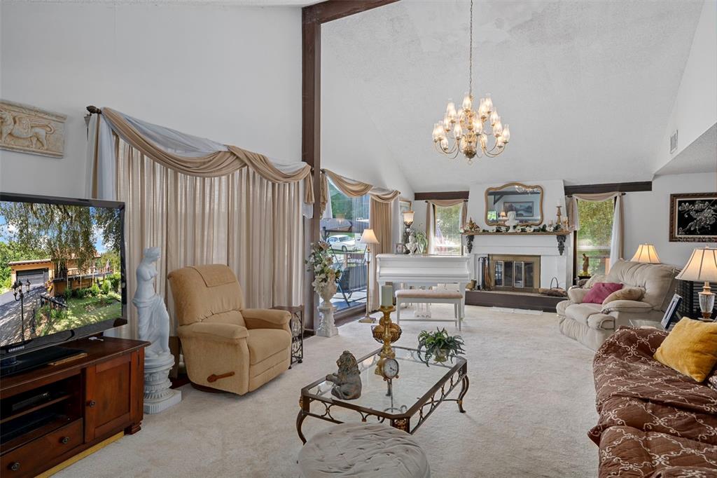 25927 Old Spring Lake Road Brooksville, FL 34601 - Photo 13 of 60 a living room with furniture a fireplace and a large window