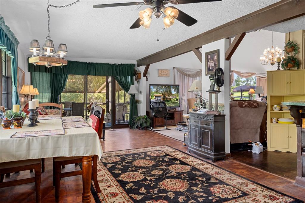 25927 Old Spring Lake Road Brooksville, FL 34601 - Photo 19 of 60 a view of a dining room with furniture a chandelier and wooden floor