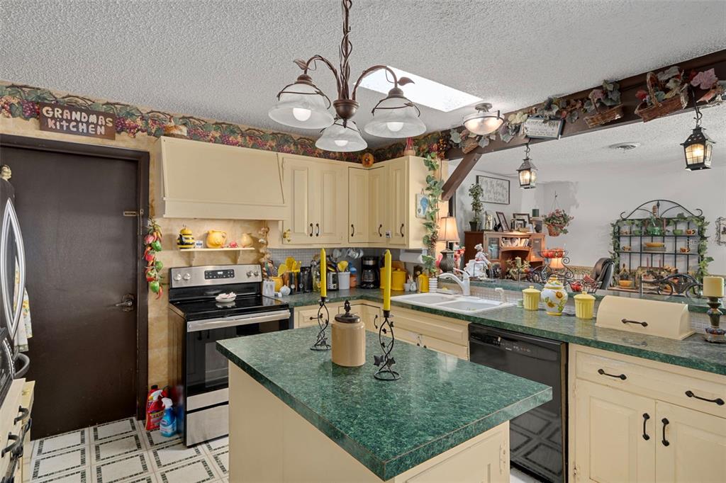 25927 Old Spring Lake Road Brooksville, FL 34601 - Photo 22 of 60 a kitchen with stainless steel appliances granite countertop a sink a stove and a wooden cabinets