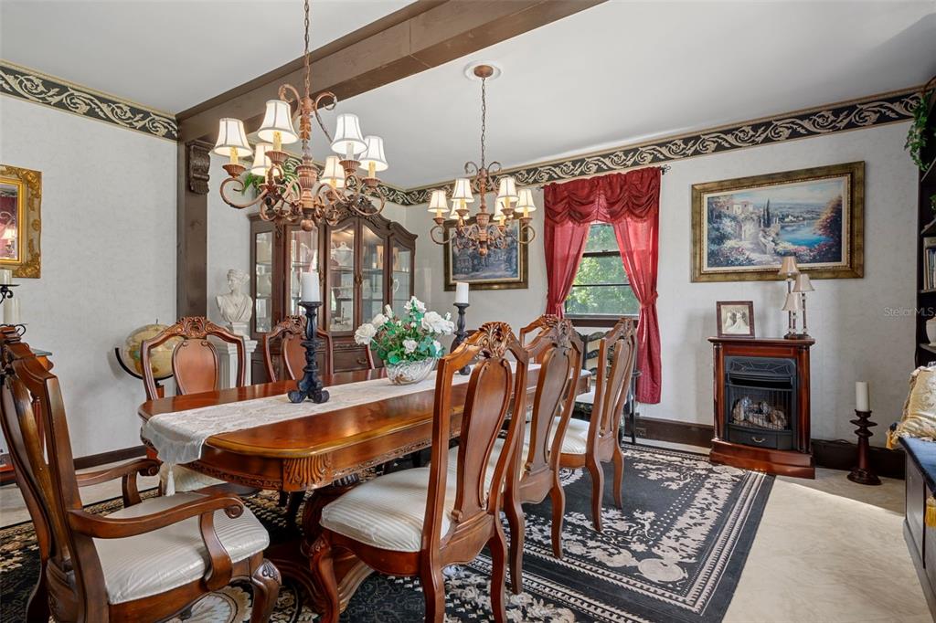 25927 Old Spring Lake Road Brooksville, FL 34601 - Photo 25 of 60 a dining room with furniture a fireplace and chandelier
