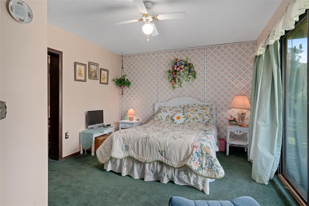 25927 Old Spring Lake Road Brooksville, FL 34601 - Photo 39 of 60 a bedroom with a bed and a chandelier