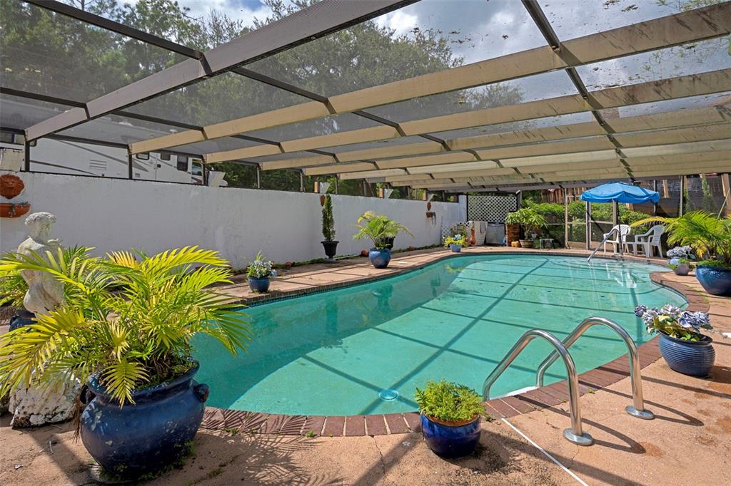 25927 Old Spring Lake Road Brooksville, FL 34601 - Photo 45 of 60 a view of a patio with table and chairs potted plants