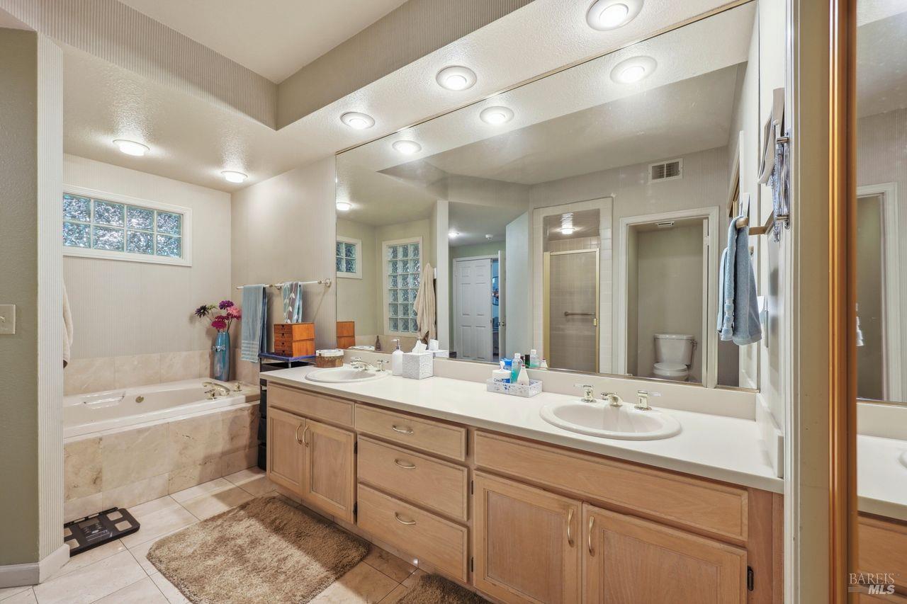 2092 Stonefield Lane Santa Rosa, CA 95403 - Photo 27 of 44 a bathroom with a sink double vanity granite tub and a mirror