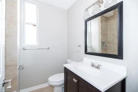 a bathroom with a sink toilet vanity and mirror